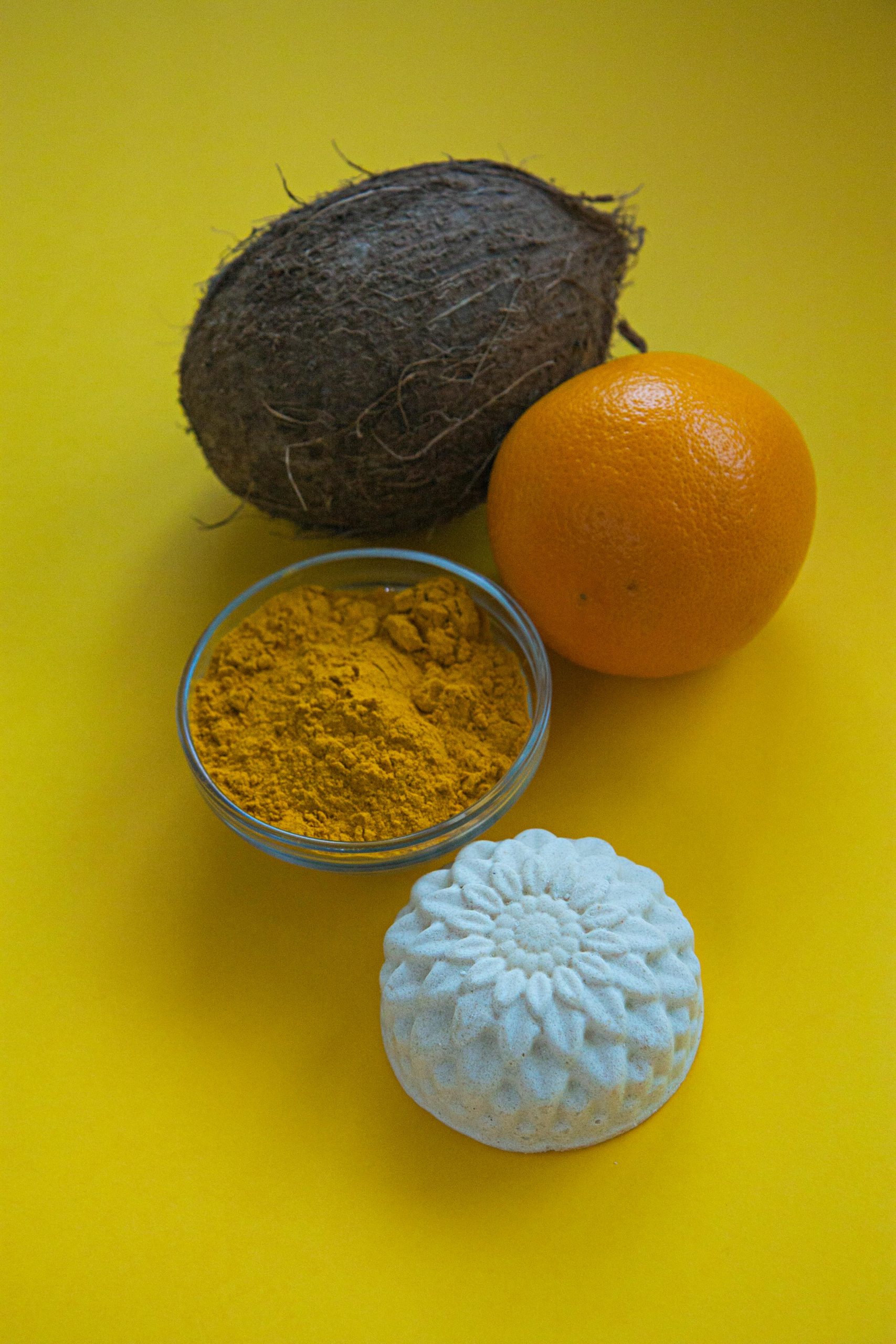 Vibrant arrangement de noix de coco, orange et curcuma sur fond jaune