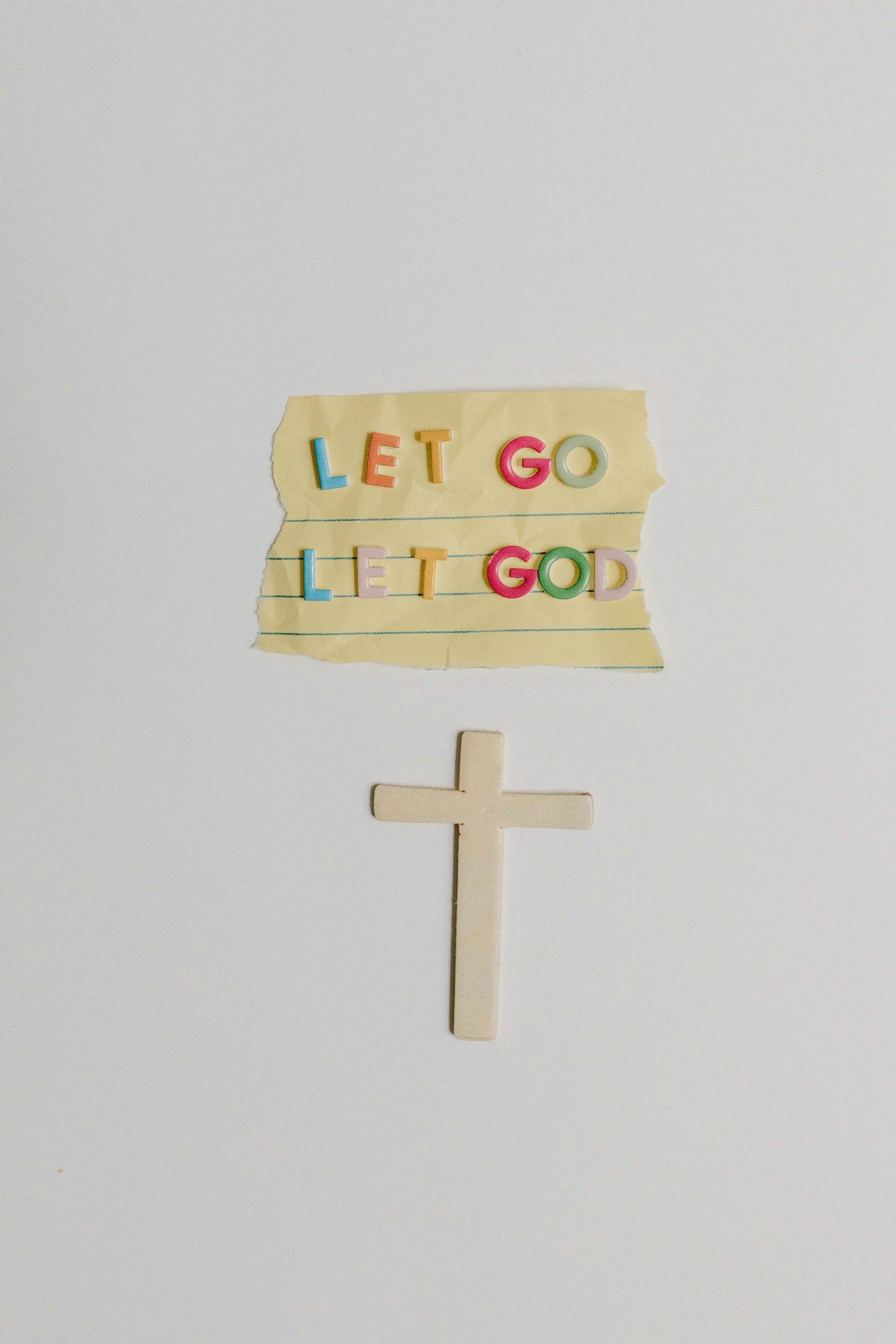 Colorful 'Let Go Let God' note et symbole de croix illustrant la foi chrétienne.