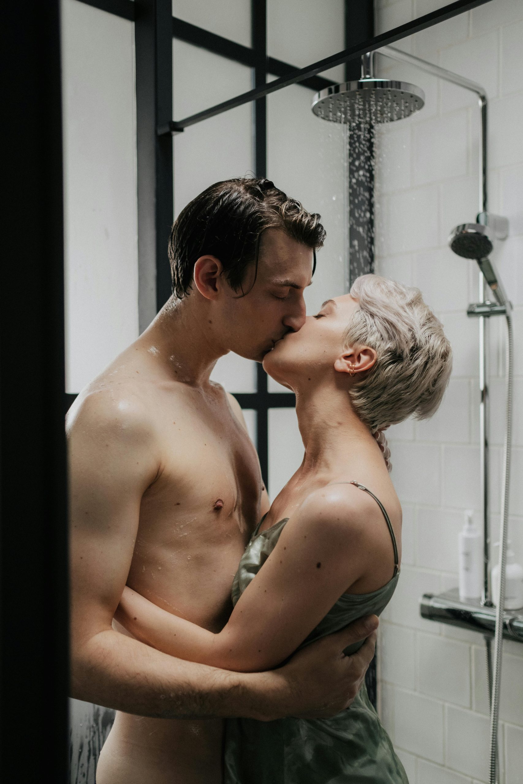 Un moment romantique capturé entre un couple s'embrassant passionnément sous une douche.