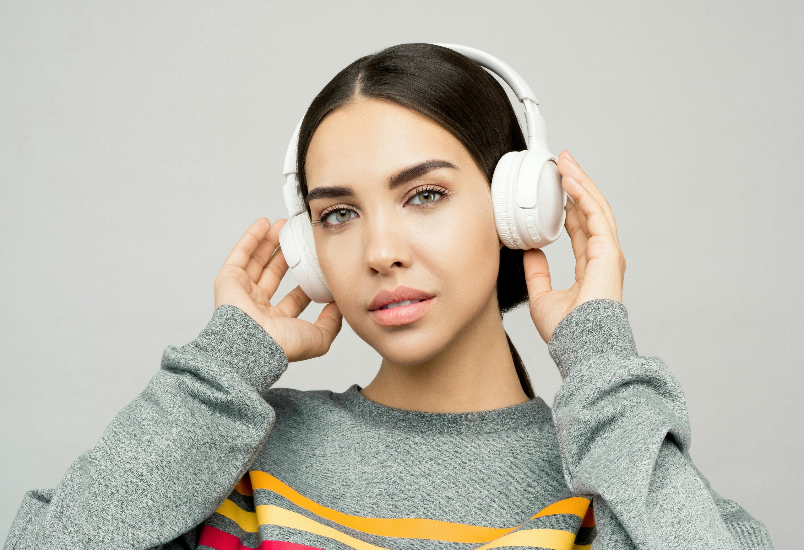 Portrait d'une jeune femme portant un casque audio, profitant de la musique à l'intérieur avec une expression détendue
