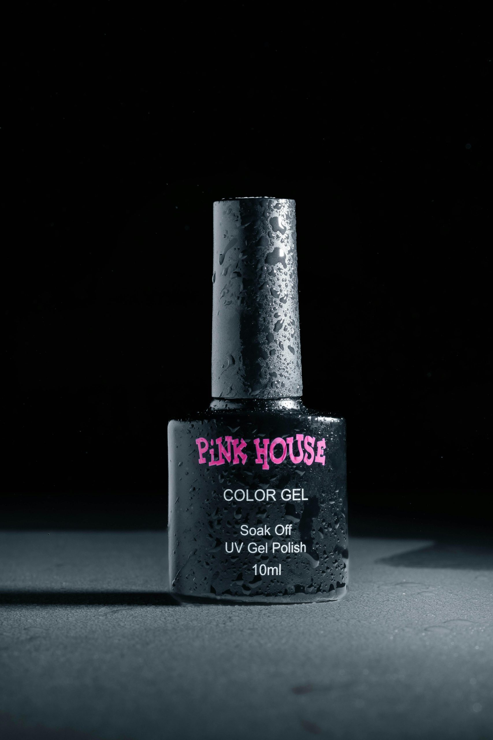 Close-up d'un flacon de vernis à ongles en gel UV avec des gouttelettes d'eau, éclairage studio.